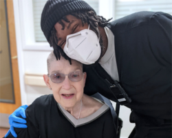 Skylark Senior Living resident being hugged by a team member wearing a mask