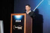 A man giving a speech at the podium during the Clearinghouse CDFI 2024 Annual Shareholders Meeting.