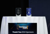 Two awards on a table at the Clearinghouse CDFI 2024 Annual Shareholders Meeting with a 'Thank You 2024 Sponsors' sign below.