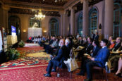 Audience members seated facing a stage at Clearinghouse CDFI's annual meeting, attentively watching a presentation.