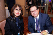 A man and woman seated and smiling at the camera during a networking session at the Clearinghouse CDFI Shareholders Meeting