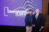 Two men posing in front of a blue backdrop displaying the Clearinghouse CDFI logo at the annual shareholders meeting.