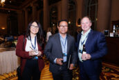 Three attendees share a light moment with drinks in hand, reflecting the congenial networking environment at the Clearinghouse CDFI Annual Shareholders Meeting