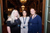 A cheerful group of three female colleagues, smiling for the camera, with one wearing a black top and the other two in professional attire, at the 2024 Annual Shareholders Meeting of Clearinghouse CDFI.