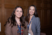 Two women smiling at the camera in a meeting room during the Clearinghouse CDFI 2024 Annual Shareholders Meeting.