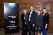 Four individuals posing for a photo by the Clearinghouse CDFI 2024 Annual Shareholders Meeting sign