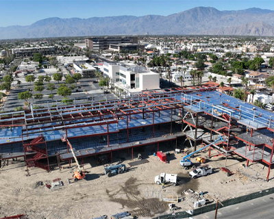 Side view of a modern educational building under construction at College of the Desert in Indio, showcasing the structural and facade work.