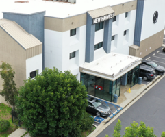 The entryway of the New Harvest Church consisting of a blue, white, and black exterior with cars parked outside on the street in front of the church.