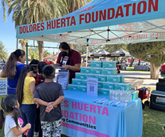 Dolores Huerta Foundation community outreach booth providing resources to local families.