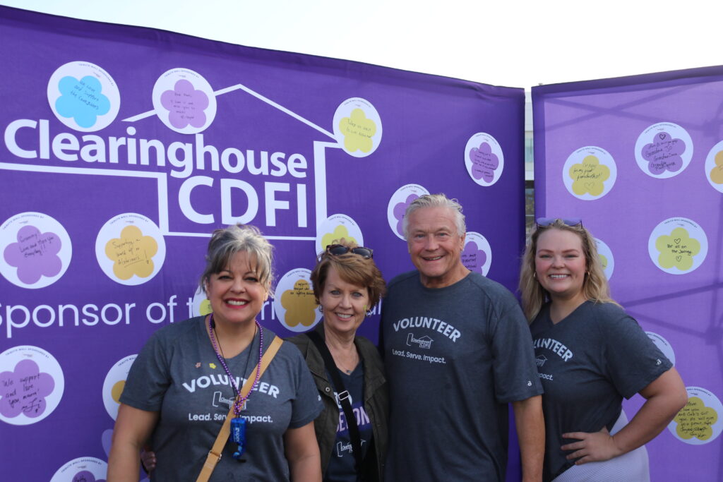 Clearinghouse CDFI team members, including President, CEO, and Founder Douglas Bystry, standing before the CCDFI Message of Hope wall at the 2025 Walk to End Alzheimer’s.