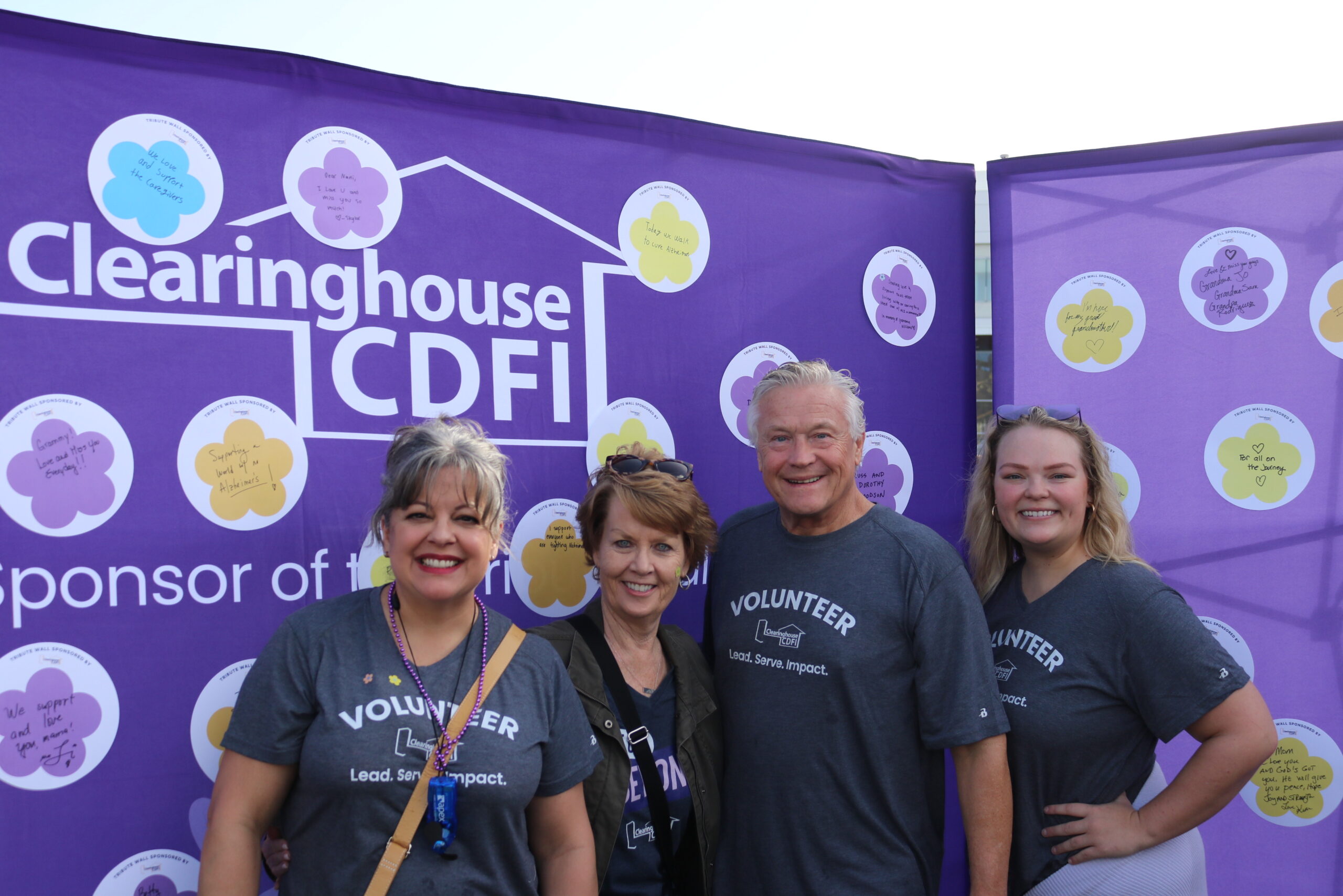 Clearinghouse CDFI team members, including President, CEO, and Founder Douglas Bystry, standing before the CCDFI Message of Hope wall at the 2025 Walk to End Alzheimer’s.