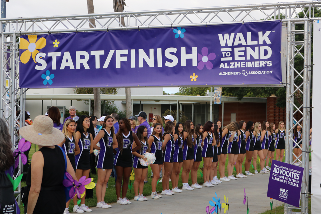 Participants gather at the starting line of the 2025 Walk to End Alzheimer’s beneath a purple banner reading “Start/Finish.”