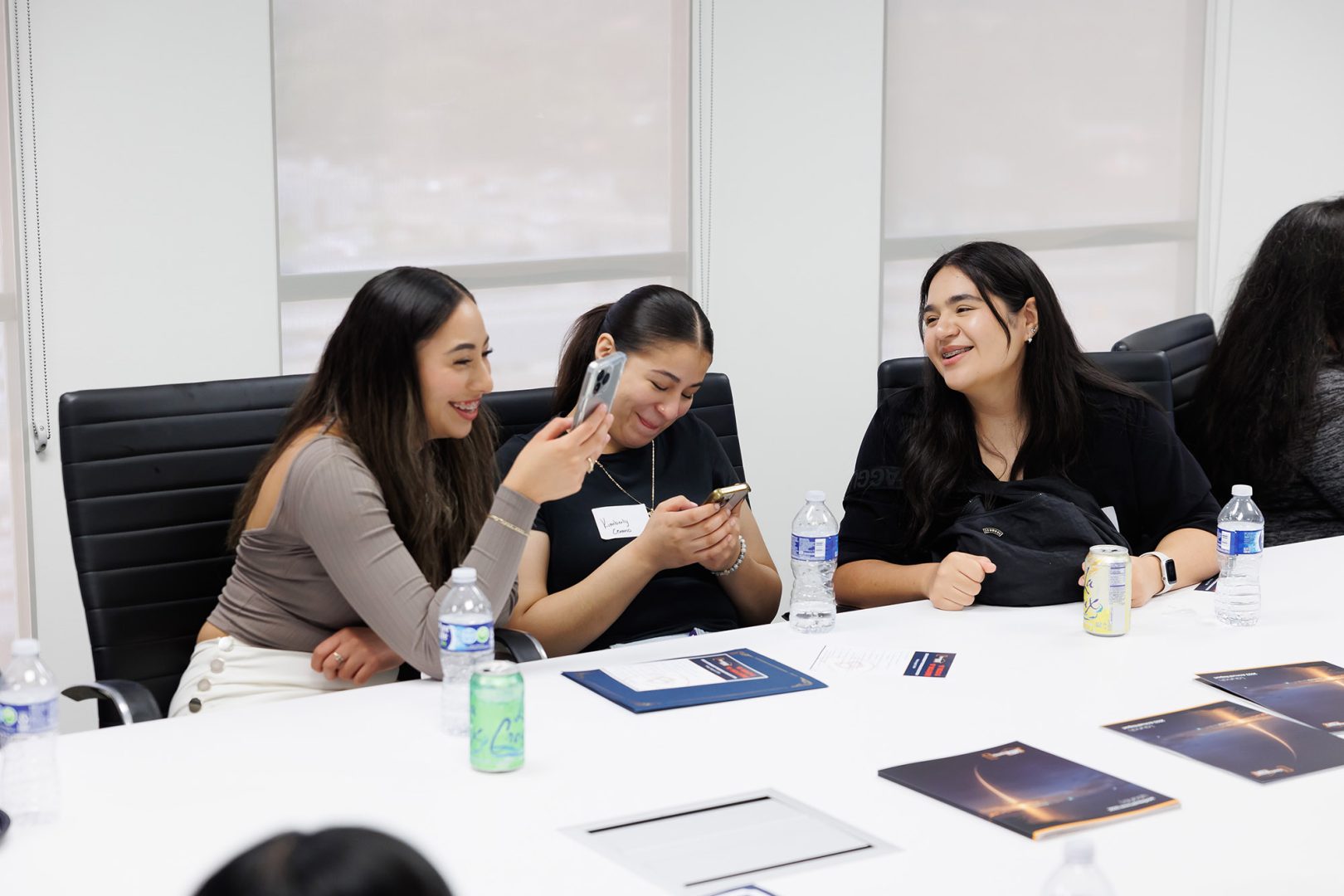Four Clearinghouse CDFI 'B' BOLD interns sitting at a table laughing and smiling